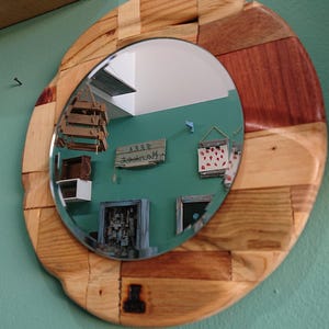Round, carved, multi wood framed mirror