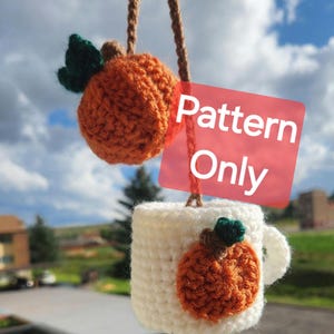 May include: Crochet pattern for a pumpkin mug cozy. The cozy is white with a small orange pumpkin on the front. The pattern is for sale, not the finished product.