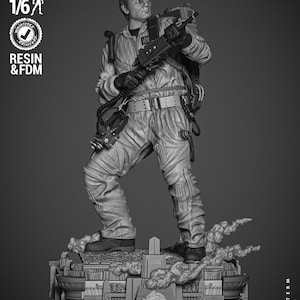 Può includere: Un modello 3D stampato in scala di grigi di un personaggio dei Ghostbusters che tiene un pacchetto di protoni e una trappola per fantasmi. Il modello è in piedi su una base con le parole "Ghostbusters" stampate su di essa. Il modello è pre-supportato e testato per la stampa in scala 1/6.