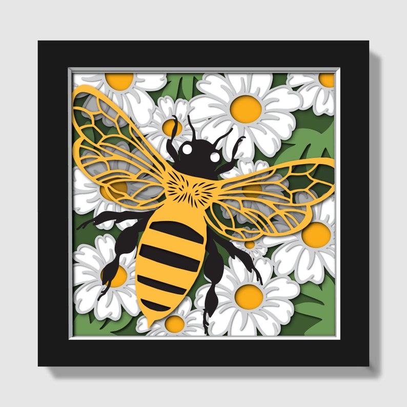 May include: A yellow and black bee with intricate wings is surrounded by white daisies with yellow centers. The bee and flowers are cut out of paper and layered to create a 3D effect.