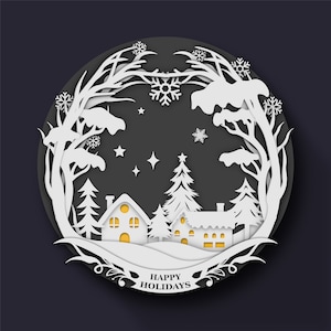 May include: A white paper cut-out design depicting a winter scene with snow-covered trees, houses with lit windows, and a snowy landscape. The design is in a circle with the text "Happy Holidays" at the bottom.