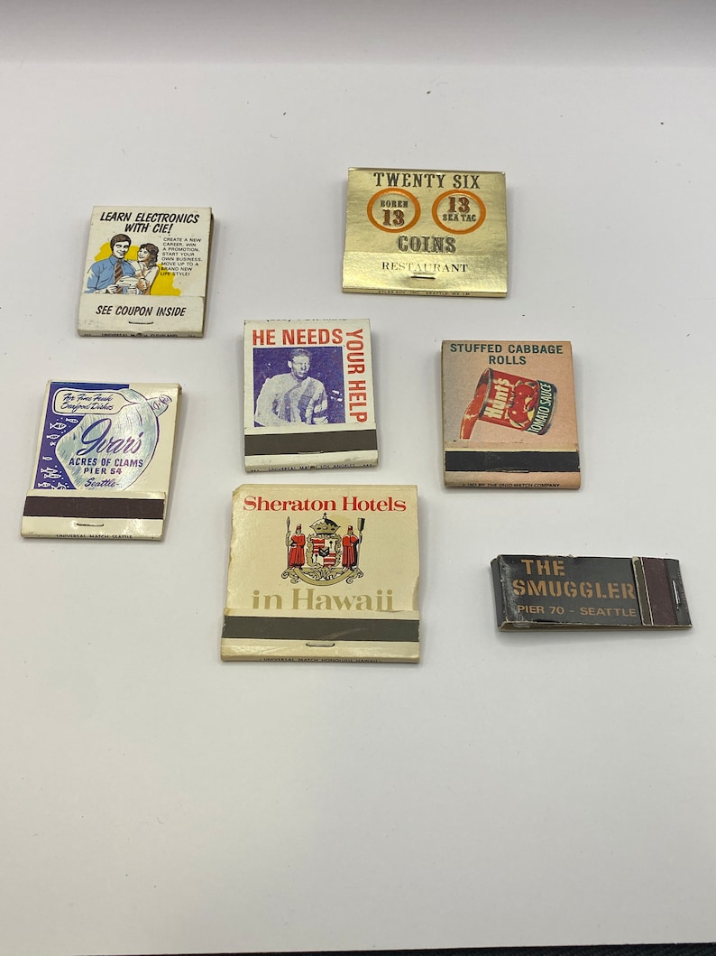 May include: Collection of vintage matchbook covers. The covers feature various designs, including a restaurant, a hotel, a seafood restaurant, and a stuffed cabbage roll. The covers are all in different colors and styles.