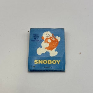 May include: A blue matchbook with a cartoon snowman holding a red apple. The text on the matchbook reads "Fresh Fruits and Vegetables" and "Snoboy". The bottom of the matchbook says "Diamond Match Div. New York, N.Y."