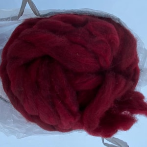 May include: A large bundle of deep red wool fiber. The wool is soft and fluffy, and it is perfect for spinning or felting.