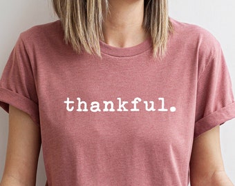 May include: A mauve t-shirt with the word "thankful." printed in white on the front.