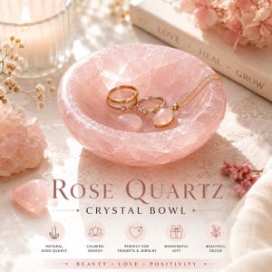 Może przedstawiać: Różowa kryształowa miska z różowego kwarcu z napisem "Rose Quartz Crystal Bowl". Misa zawiera pierścionki i naszyjnik. Na zdjęciu znajduje się również świeca, książka i dekoracyjne kwiaty.
