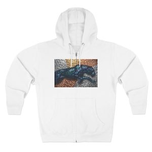 May include: White zip-up hoodie with a front pocket and a hood. The hoodie features a graphic of a dark blue and green panther on a textured background of silver, gold, and copper.