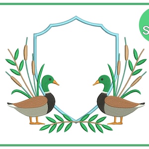 May include: An embroidered design featuring two ducks facing each other, with green heads and brown bodies, framed by a light blue shield shape. The design includes cattails and green leaves, with the text "37 Sizes" in a green circle.