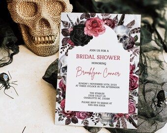 May include: A rectangular bridal shower invitation card featuring a floral border of black and red roses, skulls, and feathers. The text reads: JOIN US FOR A BRIDAL SHOWER HONORING Brooklynn Conner SUNDAY NOVEMBER 10TH, 2023 AT THREE O'CLOCK IN THE AFTERNOON THE STABLES 2356 CALLY LN CHARLOTTE NC, 23568 PLEASE RSVP TO SARAH AT XXX-XXX-XXXX.