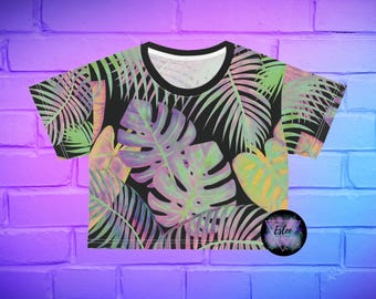 May include: A black crop top with a tropical leaf print in shades of pink, green, and yellow. The leaves are stylized and have a watercolor effect.