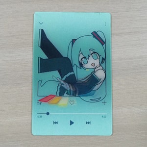 May include: A teal blue music player with a cartoon illustration of a green-haired anime character. The player has a play button, rewind and fast forward buttons, and a volume control. The time display shows 0:29 and 4:16.