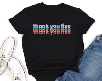 May include: Black t-shirt with the text "thank you five" repeated three times in a gradient of blue, orange, and red.