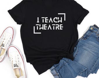 May include: Black t-shirt with white text that reads "I Teach Theatre" in a stylized font.