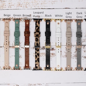 May include: Ten different colored Apple Watch bands. The bands are made of leather and have a rose gold buckle. The colors are pink, beige, green, brown, leopard print, black, white, light grey, dark grey, and leopard pattern.