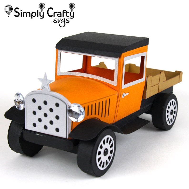 Peut inclure: Mod&egrave;le de camionnette vintage en papier orange et noir avec une benne en bois. Le camion a une &eacute;toile &agrave; l'avant et un toit noir.
