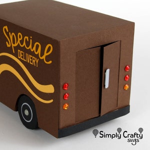 K&ouml;nnte beinhalten: Ein brauner Papp-Lieferwagen mit den Worten "Special Delivery" auf der Seite. Der Wagen hat eine Heckklappe, die offen ist und einen silbernen Griff hat. Der Wagen hat drei rote und orange Lichter hinten.