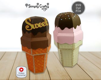 Puede incluir: Dos decoraciones de cono de helado de papel. Uno es marrón con la palabra "Sweet" en escritura dorada. El otro es rosa y marrón con chispas. Los conos son naranja y verde, respectivamente. La imagen incluye un icono de tutorial en vídeo y una etiqueta de archivo de corte SVG.