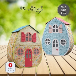 Puede incluir: Dos casas decorativas de papel con patrones florales y texturizados. Una casa es azul claro con un techo rosa, la otra es beige con un techo azul. Cada una tiene ventanas, puertas y el texto "SVG Cut File".