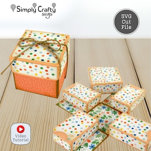 May include: A collection of colorful paper gift boxes with polka dots and floral patterns. The boxes are orange, white, and have a twine bow. The image includes the text "Simply Crafty svgs" and "SVG Cut File".