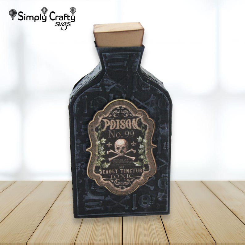 May include: A black papercraft bottle with a tan cork stopper, featuring a repeating pattern of skulls and bones. A central ornate label displays the text Poison No. 99, Deadly Tincture, and Toxic, accompanied by a skull and crossbones graphic.