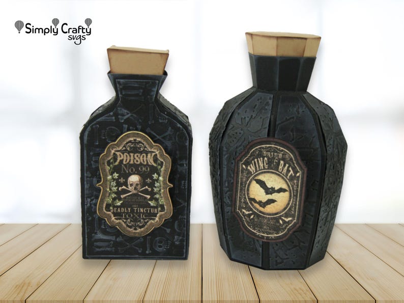 May include: Two black decorative bottles with tan cork stoppers. The left bottle features a label reading Poison No. 99 Deadly Tincture Toxic with a skull and crossbones. The right bottle features a label reading Dried Wing of Bat with bats.
