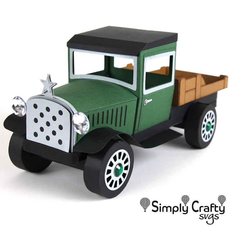 Peut inclure: Mod&egrave;le de camionnette vintage en papier, de couleur verte et noire, avec une benne en bois. Le camion a une &eacute;toile sur l'avant et des phares en forme de diamant.