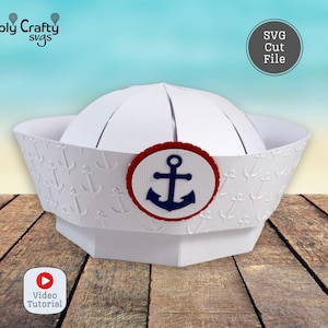 May include: A white paper sailor hat with an embossed anchor pattern. The hat features a navy blue anchor emblem within a red circle. The image includes the text "SVG Cut File" and "Video Tutorial".