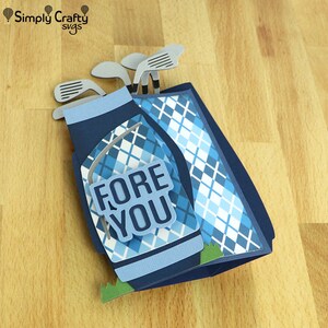 May include: A blue and white golf bag with a plaid pattern and the words "FORE YOU" on the front. The bag is decorated with silver golf clubs.