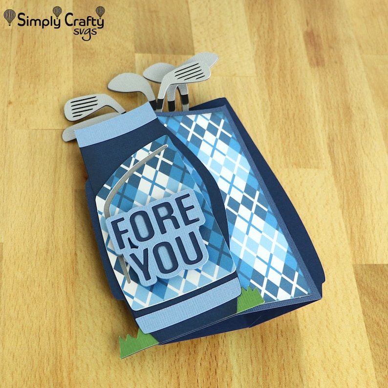 May include: A blue and white golf bag with a plaid pattern and the words "FORE YOU" on the front. The bag is decorated with silver golf clubs.