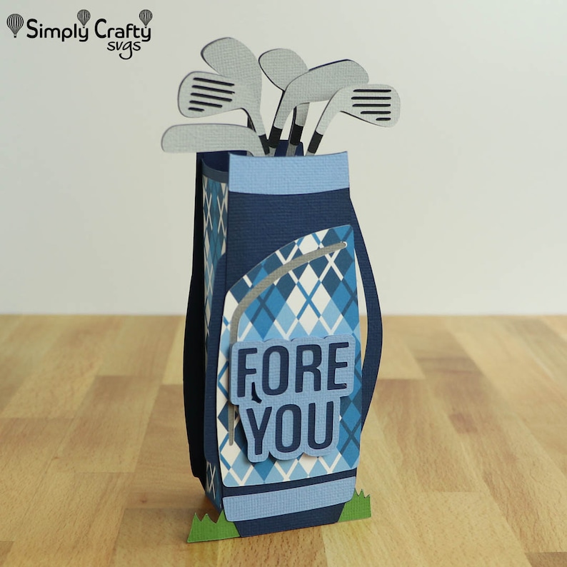 May include: A blue and white golf bag with a plaid pattern and a set of golf clubs sticking out of the top. The bag has a blue and white sign that says "FORE YOU".