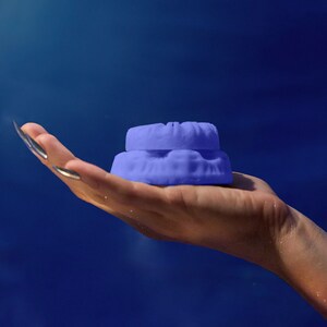 May include: A pair of stacked purple silicone mouth guards. The mouth guards are designed to protect teeth during sports or other activities.