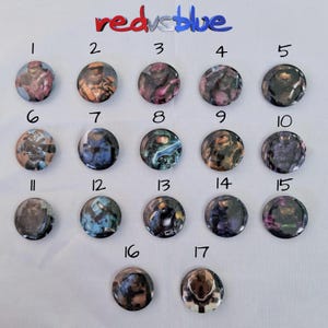 May include: A collection of seventeen round buttons with various designs, numbered 1 through 17. The buttons feature images of characters from the video game Halo. The text "red vs blue" is at the top of the image.