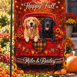 Puede incluir: Una bandera de jardín rectangular que muestra una camioneta roja con un golden retriever y un labrador negro en la parte trasera. El diseño incluye el texto Happy Fall y Milo & Bailey, un corazón a cuadros, luces, girasoles y calabazas.