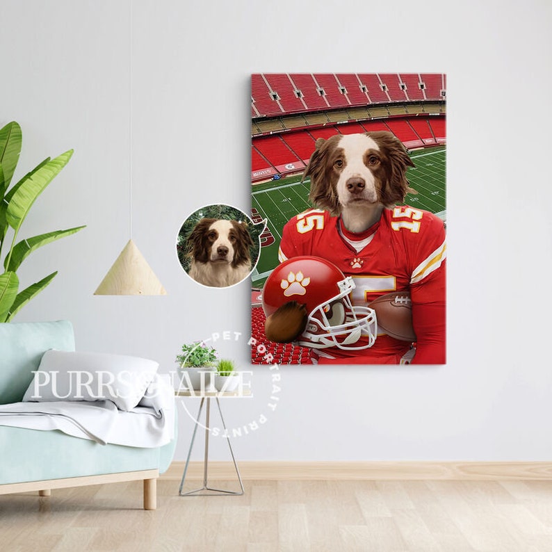 May include: A brown and white dog wearing a red and white football jersey and holding a football helmet. The dog is standing on a green field with a red and white stadium in the background.