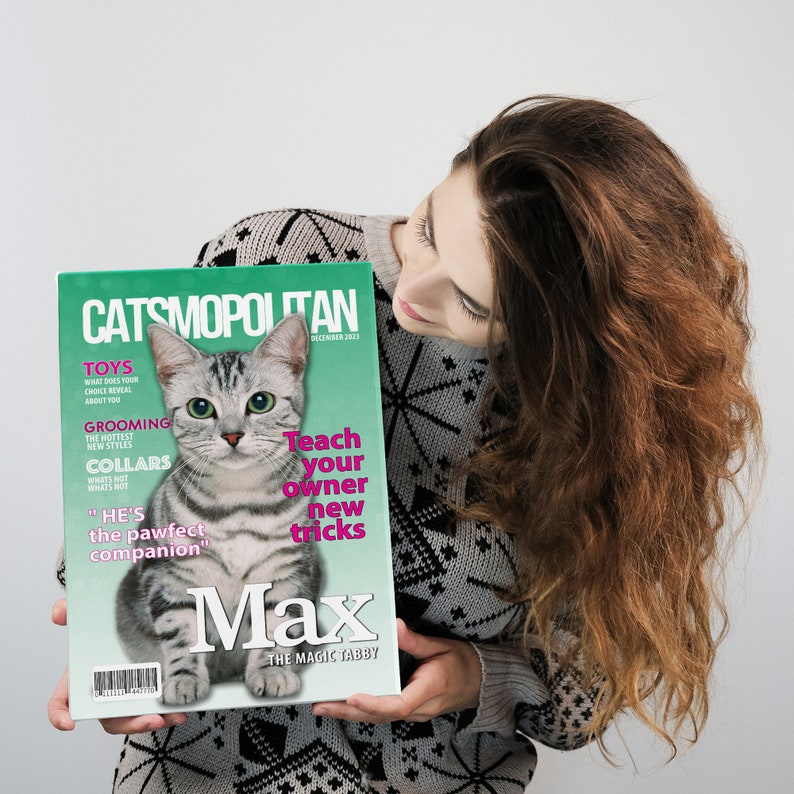 Pu&ograve; includere: Una copertina di rivista con un gatto tabby argentato con occhi verdi. La rivista si chiama "Catsmopolitan" e il gatto si chiama "Max, The Magic Tabby". La copertina presenta anche il testo "Teach your owner new tricks".