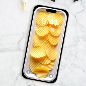May include: A white smartphone with a black frame and a clear case. The case contains a pile of yellow potato chips. The phone's screen displays the time, "9:41", and the date, "Monday, June 6".