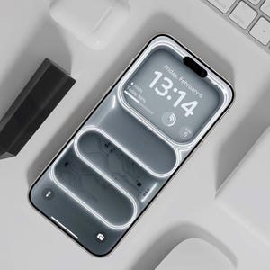 May include: A smartphone displaying the time, date, and weather details. The phone has a silver frame and a white background. A white keyboard, wireless earbuds, and a black rectangular object are also present in the image.