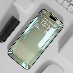 Puede incluir: Un teléfono inteligente con una pantalla reflectante que muestra la hora, la fecha y la información meteorológica. El teléfono tiene un marco plateado y está rodeado por un teclado blanco, auriculares inalámbricos y otros accesorios.