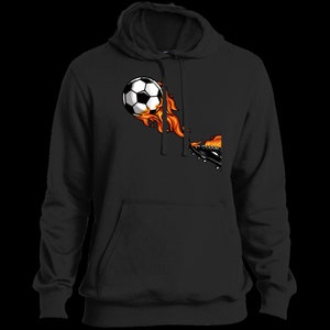 Puede incluir: Sudadera con capucha negra con un gráfico de un balón de fútbol en llamas que es pateado por un pie con una bota negra.