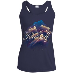 Puede incluir: Camiseta de tirantes azul marino con un diseño inspirado en la galaxia con nubes y estrellas. El texto "Be Yourself" está escrito en una fuente de letra dorada.