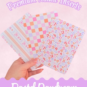 May include: Three pastel-colored Kindle inserts with different patterns are held in a hand. The patterns include stripes with butterflies, a checkerboard, and a leopard print. The text "Premium Kindle Inserts" and "Pastel Daydream" are displayed.