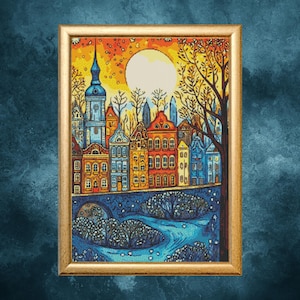 May include: A framed artwork depicting a colorful cityscape at sunset. The buildings are in shades of blue, orange, and red, with a large moon in the sky. A river flows in the foreground, and a tree is on the right side.