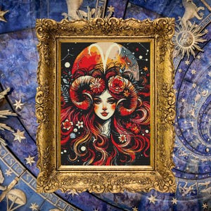 Peut inclure: Une illustration encadrée d'une femme avec des cornes de bélier et des fleurs dans les cheveux. L'arrière-plan est bleu foncé avec des étoiles et une lune croissante.