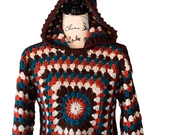 May include: A handmade crochet hoodie in a granny square pattern. The sweater features a color palette of brown, teal, white, and orange. The hoodie has a hood and long sleeves. The text "Clara's Lake" is visible on the mannequin.
