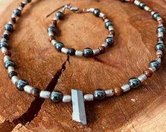 May include: A silver and brown beaded necklace with a silver pendant and a matching bracelet. The necklace and bracelet are made of hematite and wood beads.