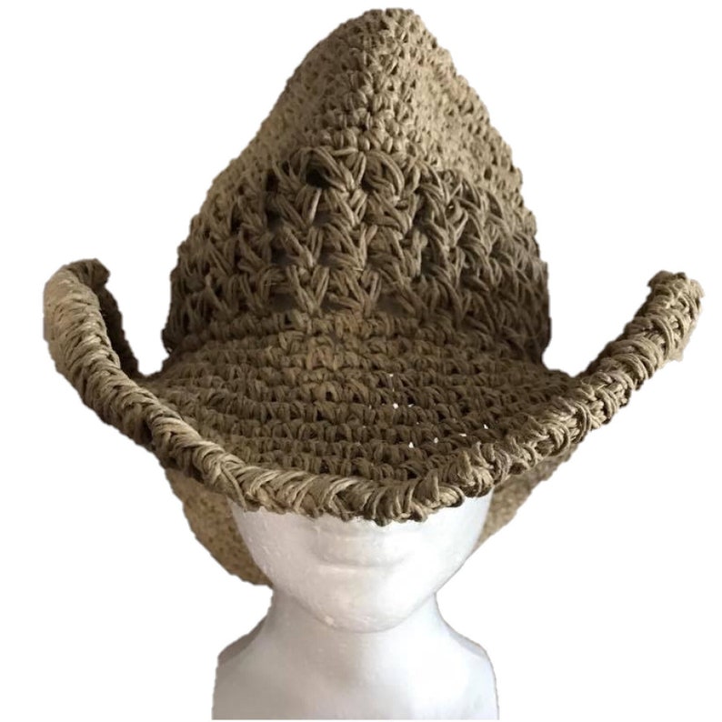 May include: A tan crocheted cowboy hat with a wide brim and a pointed crown. The hat is made of a natural fiber and has a rustic, handmade look.