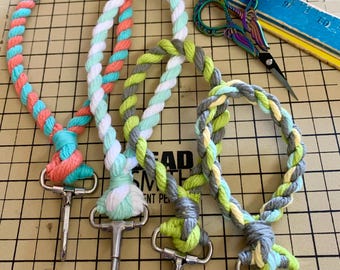 May include: Three colorful braided ropes with metal clasps. The ropes are braided with white, green, yellow, gray, and coral colored yarn.