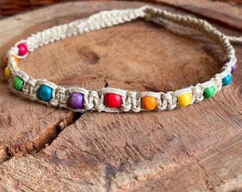May include: A rainbow colored beaded hemp necklace with a macrame knot design.