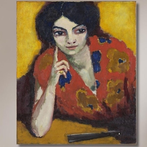 Puede incluir: Pintura al óleo de una mujer con un top con estampado floral rojo y amarillo, con fondo amarillo. La mujer tiene el pelo oscuro y apoya el brazo en una mesa. Un abanico negro está sobre la mesa. La pintura está colgada sobre un sofá amarillo.