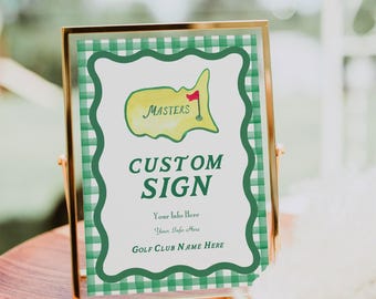 Puede incluir: Un cartel con marco dorado y fondo a cuadros verde y blanco. El cartel presenta una ilustración amarilla y verde de un campo de golf con la palabra "MASTERS" y el texto "CUSTOM SIGN" en letras negras y negritas. El cartel también incluye el texto "Your Info Here" y "GOLF CLUB NAME HERE".
